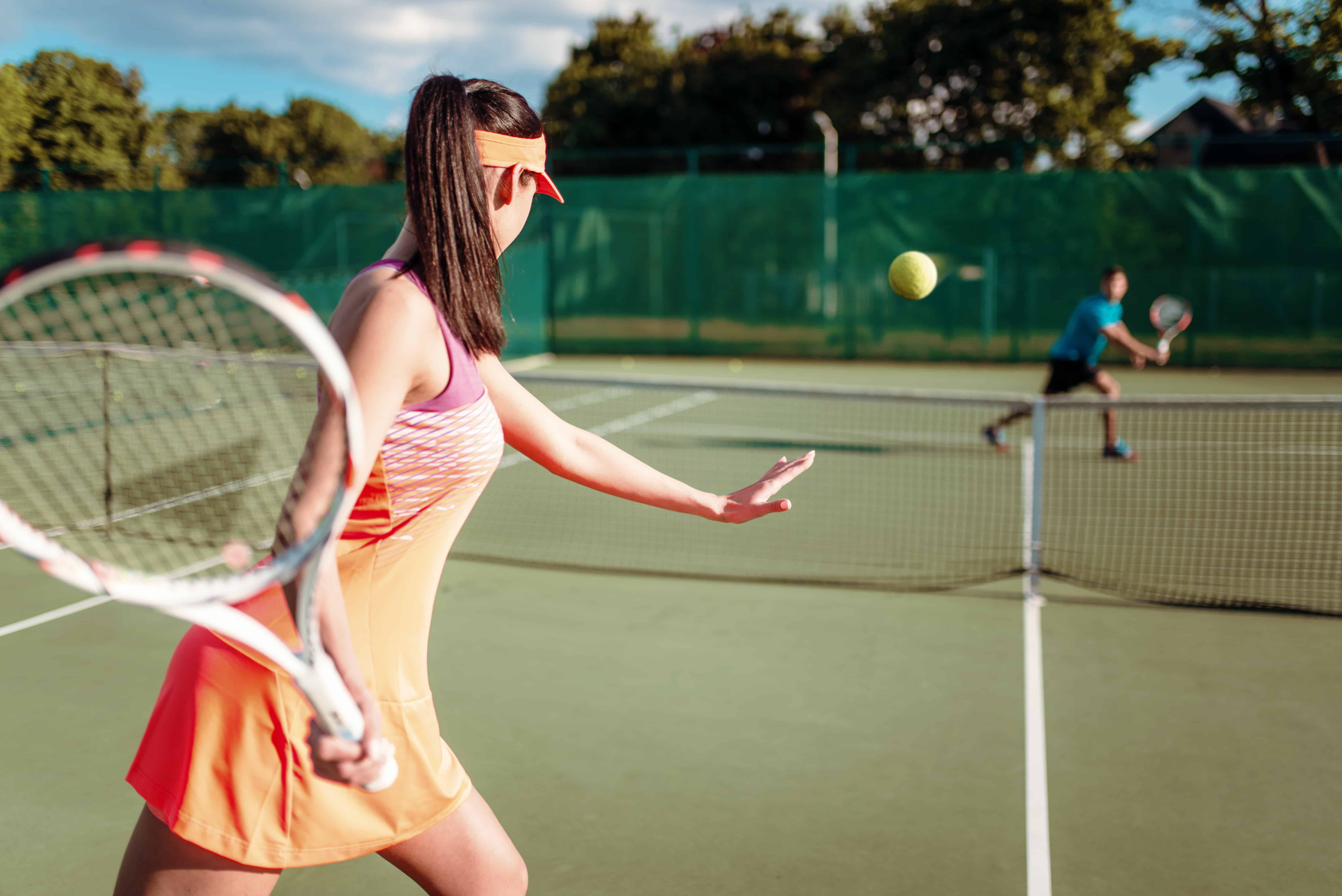 Man and Woman Playing Tennis on tennis court